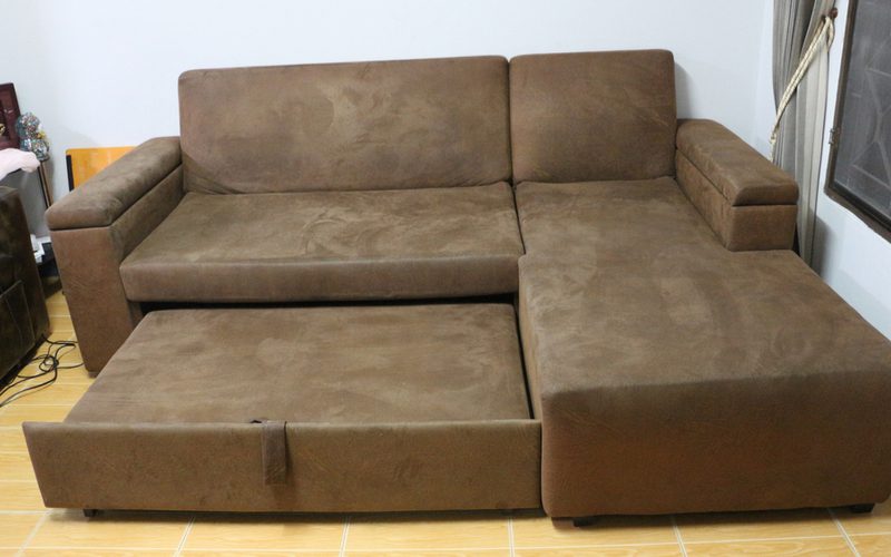 В качестве изображения дивана стандартных размеров коричневый диван из искусственной замши, выдвинутый в кровать.