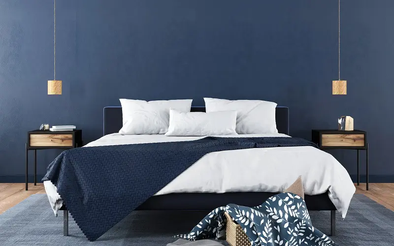 Спальня с темно-синими стенами и белыми простынями